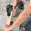 Person verschraubt Holzbalken mit einem Akku-Bohrschrauber von Bosch.