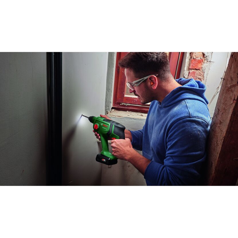 Person bohrt mit Bohrhammer in Wand.