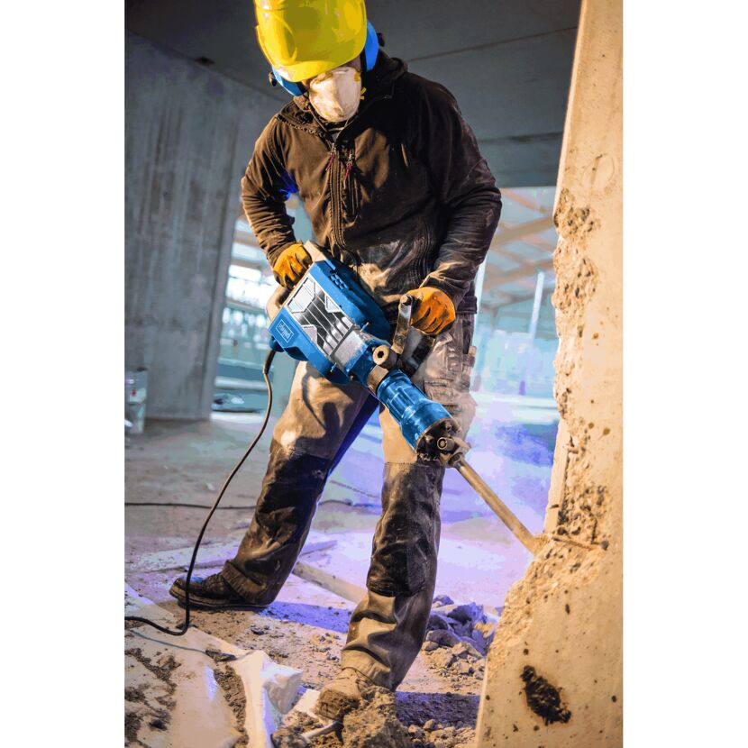 Person benutzt Abbruchhammer an Betonwand.