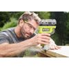 Person fräst mit einer Akku-Kantenfräse von Ryobi Holz.
