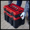 Person trägt zwei ineinander gesteckte Einhell Systemkoffer