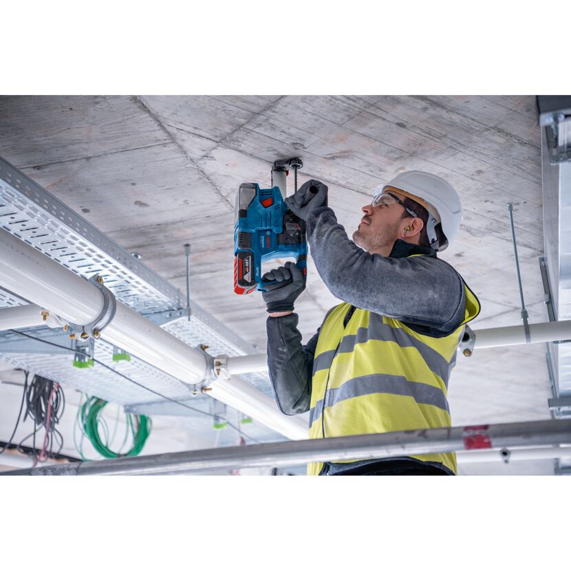 Person bohrt mit Bohrhammer in Decke