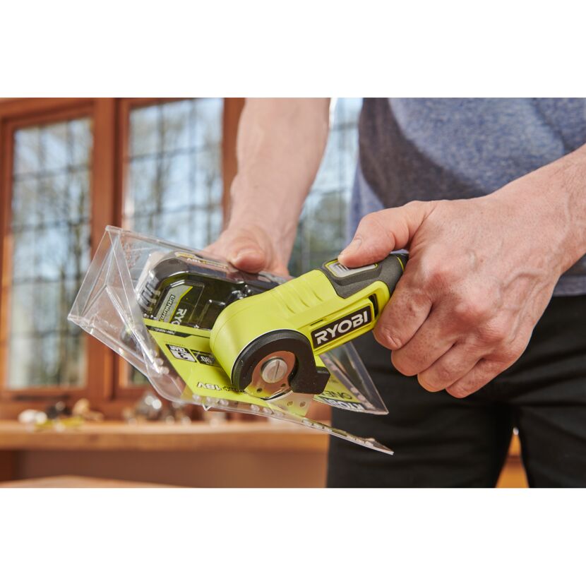 Person schneidet Verpackung mit RYOBI Akku-Schneidegerät