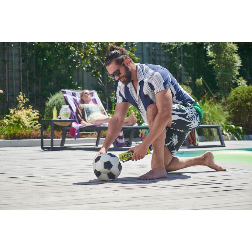 Person pumpt Fußball mit Kompressor auf