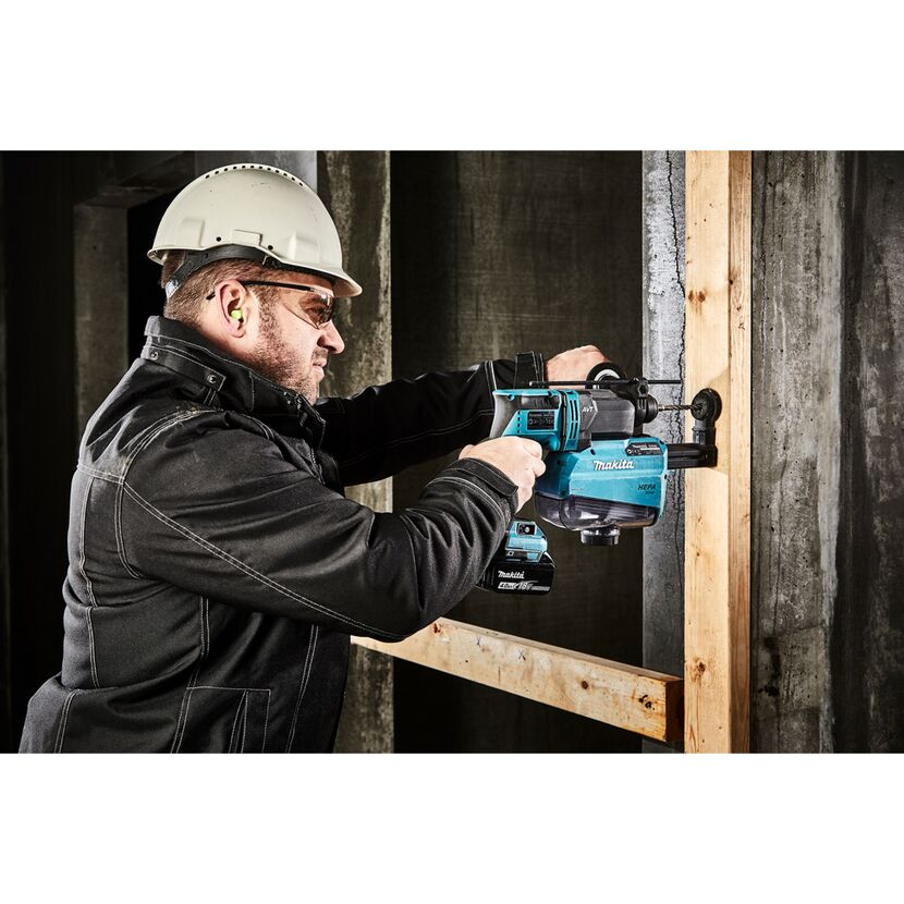 Person bohrt mit einem Kombihammer in eine Wand
