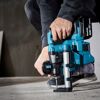 Person bohrt mit Akku-Bohrhammer in Betonboden
