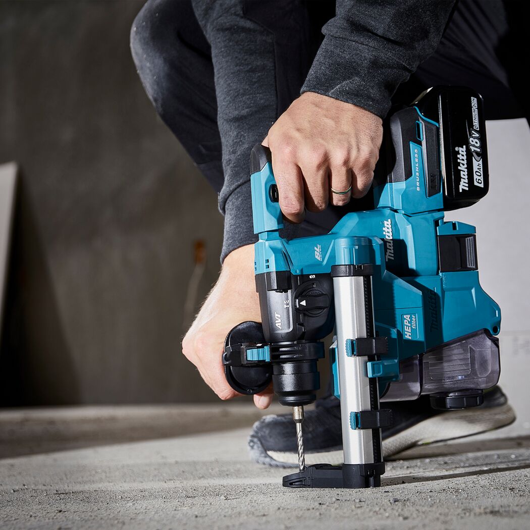 Person bohrt mit Akku-Bohrhammer in Betonboden