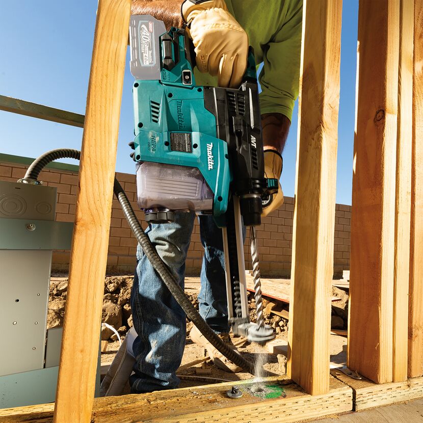 Person bohrt mit einem Bohrhammer in Holz