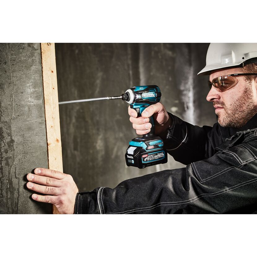Person schraubt Holzlatte an Wand