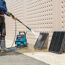 Person reinigt Gitter mit Hochdruckreiniger