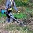Person mäht Gras mit Freischneider