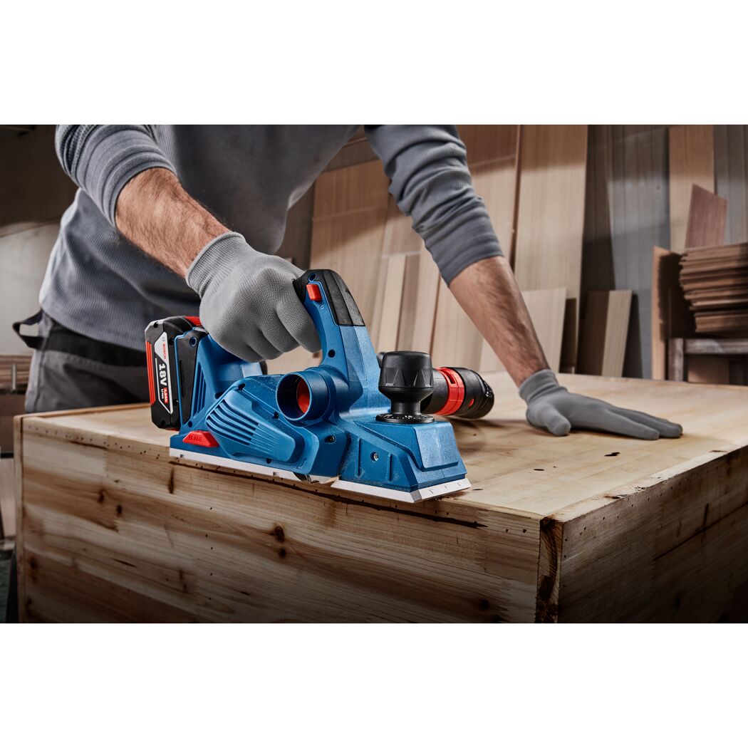 Person bearbeitet Holz mit Elektrohobel