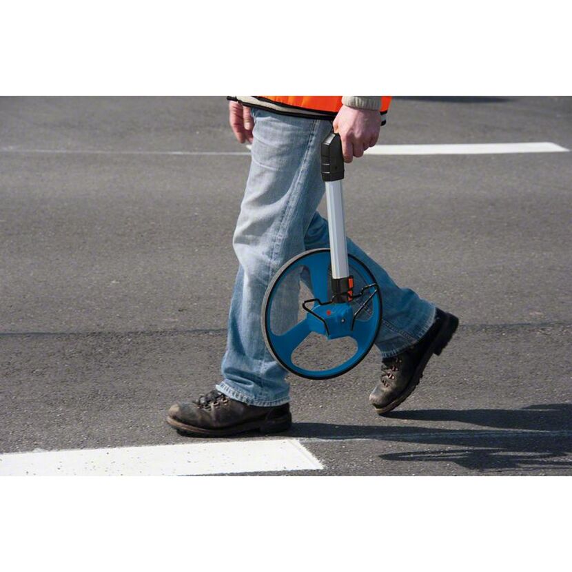 Person misst Strecke mit Messrad