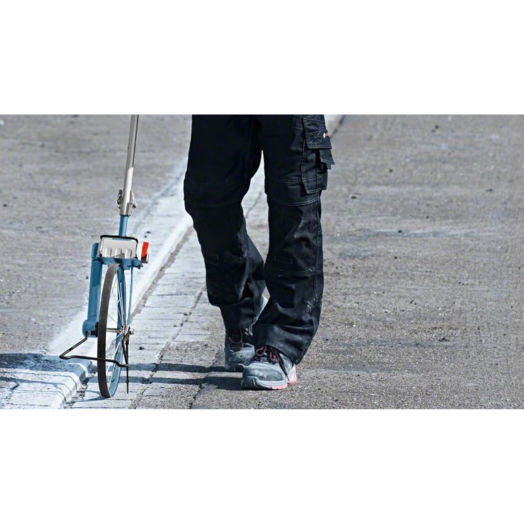 Person misst Strecke mit Messrad