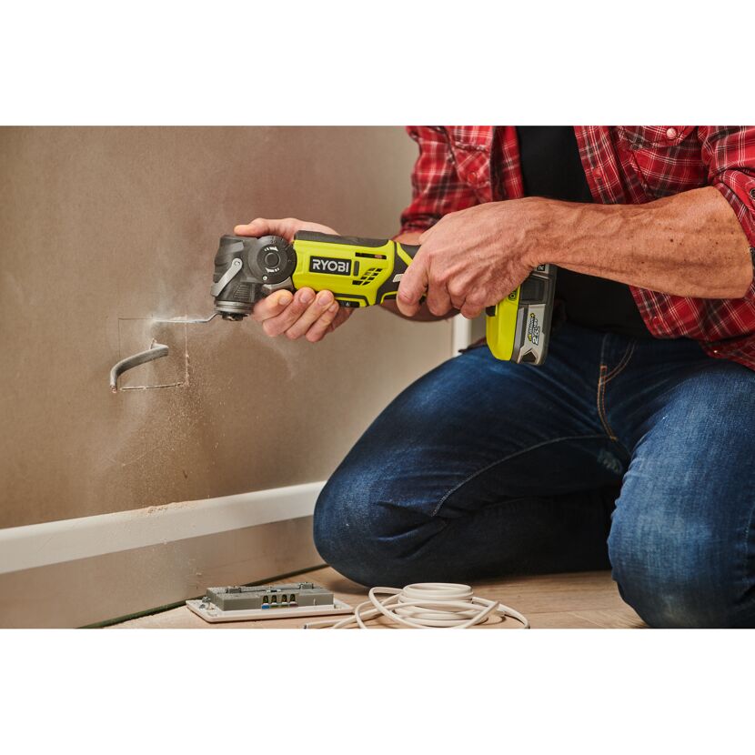 Person schneidet mit RYOBI Akku-Multitool eine Öffnung in die Wand.