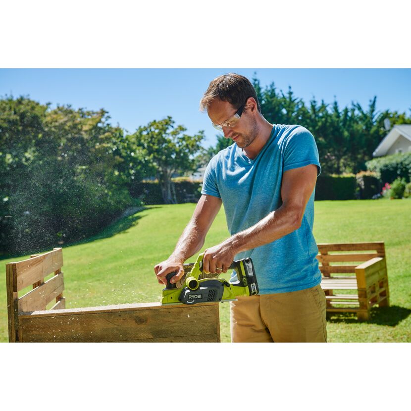 Person hobelt Holz mit Akku-Hobel