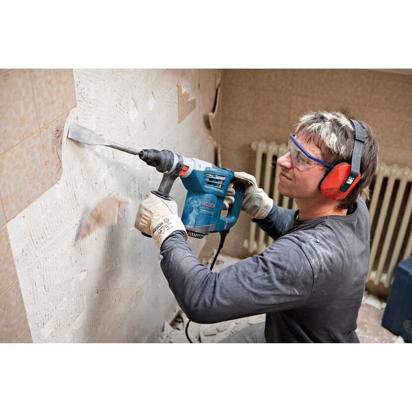 Person entfernt Fliesen mit dem Boschhammer