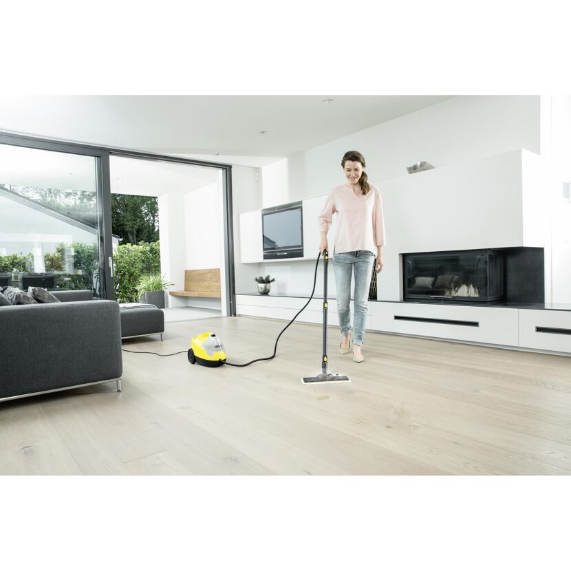 Person reinigt Holzboden mit Dampfreiniger.