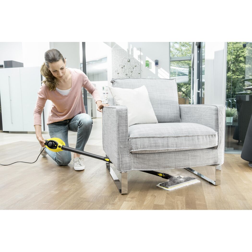 Person reinigt Sofa mit Dampfreiniger
