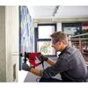 Person bohrt mit einem Bohrhammer in eine Betonwand.