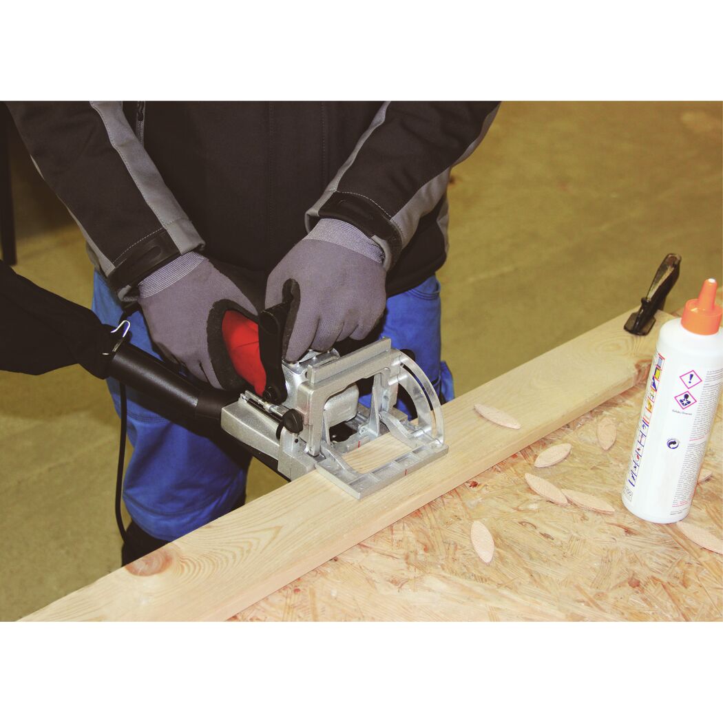 Person fräst mit Flachdübelfräse TC-BJ 900 ein Holzbrett.