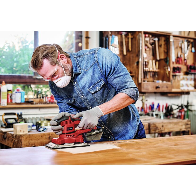 Person schleift Holz mit Schwingschleifer