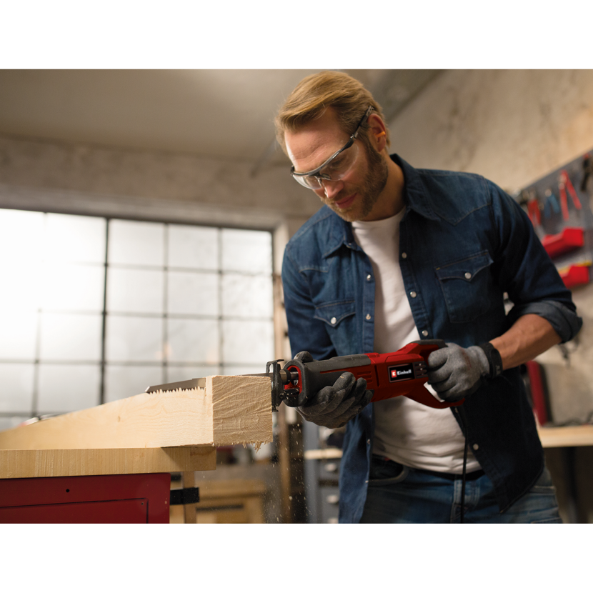 Person sägt mit einer Einhell Universalsäge ein Holzstück.