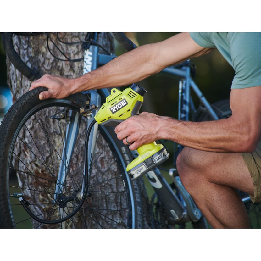 Person pumpt mit dem Ryobi 18V Handkompressor ein Fahrrad auf.