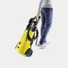 Person transportiert einen Kärcher Hochdruckreiniger.
