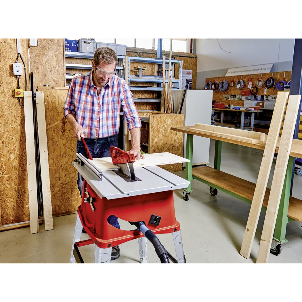 Person sägt Holz mit Tischkreissäge.