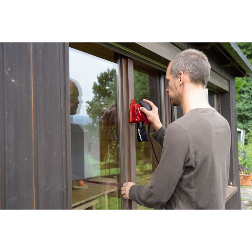 Person schleift Fensterrahmen mit Multischleifer