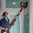 Person schleift mit Trockenbauschleifer eine Wand