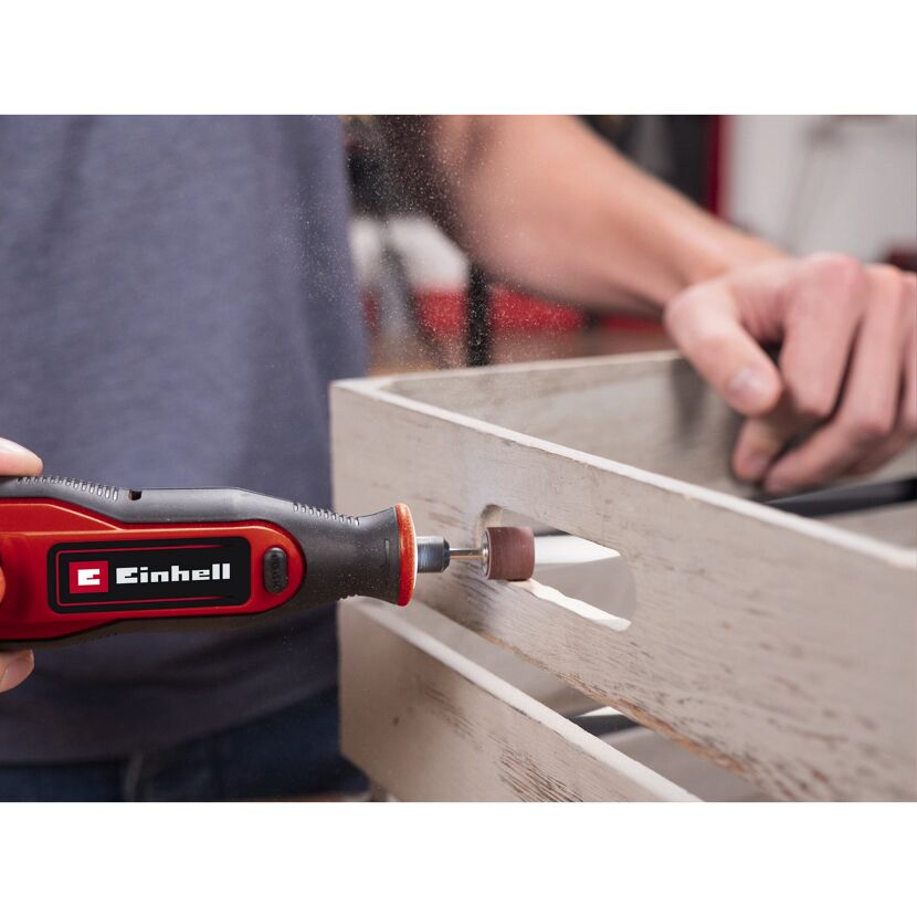 Person schleift mit einem Einhell Akku-Multitool eine Holzkiste.
