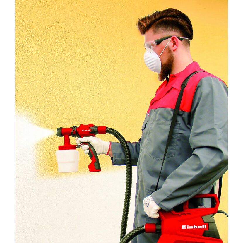 Person beim Besprühen einer Wand mit dem Farbsprühsystem TC-SY 700 S von Einhell