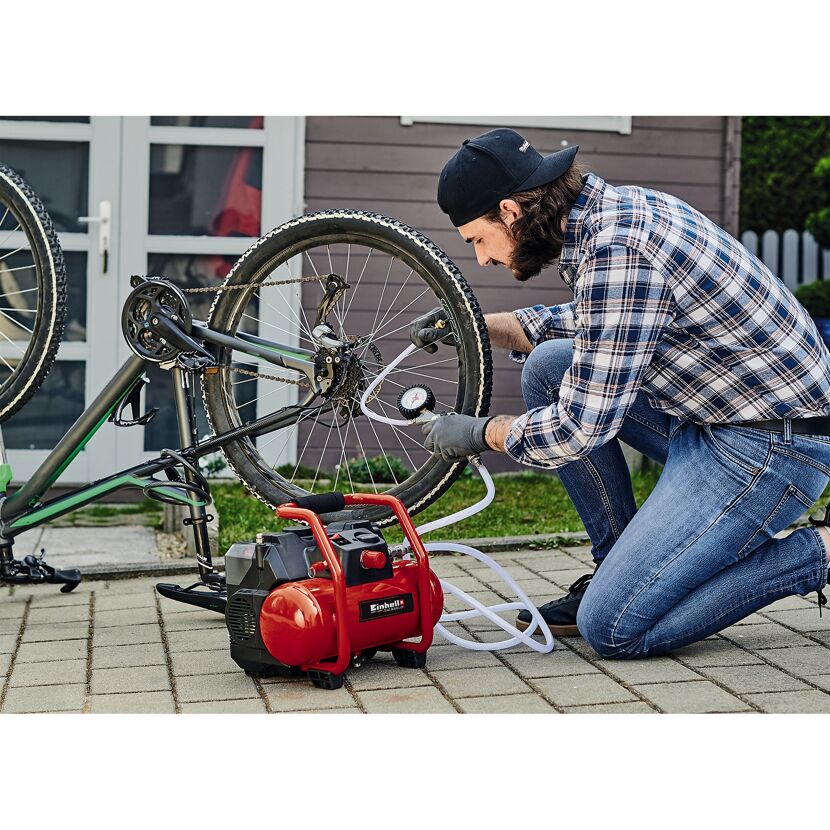 Person pumpt mit einem Einhell Akku Kompressor ein Fahrrad auf.