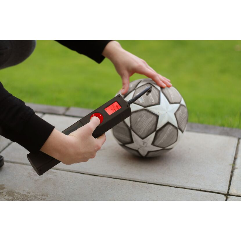 Person pumpt mit Akku Mini Kompressor einen Fußball auf.