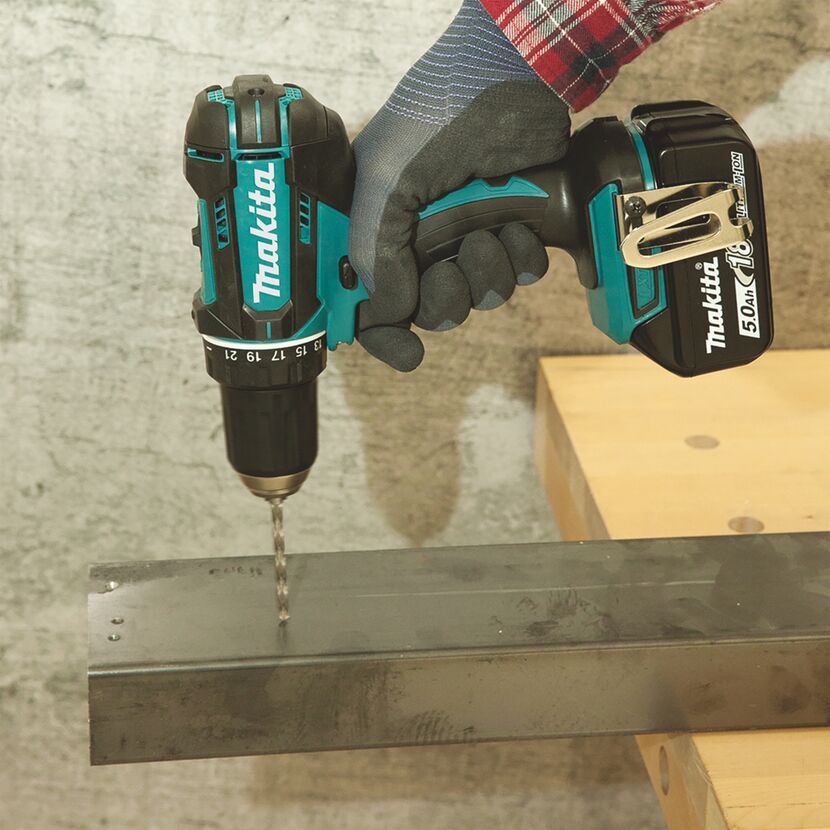 Person bohrt mit einem Makita Akku-Bohrschrauber in Metall.