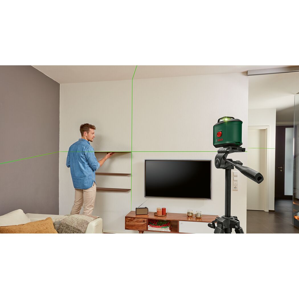 Person bringt mit Kreuzlinienlaser ein Regal an
