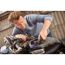 Person poliert den Tank eines Motorrads mit einem Schleifer