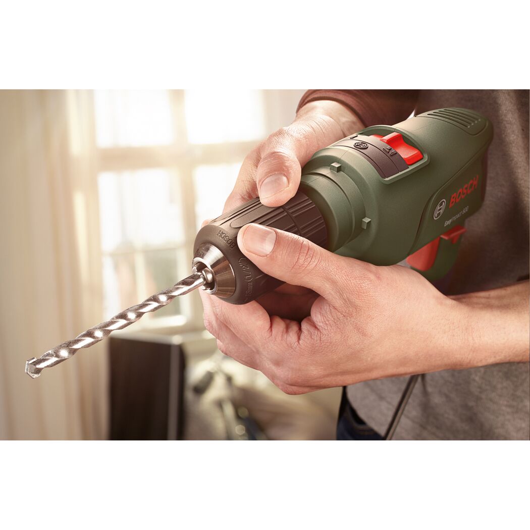 Person hält eine Bosch Schlagbohrmaschine EasyImpact 600 mit Bohrer