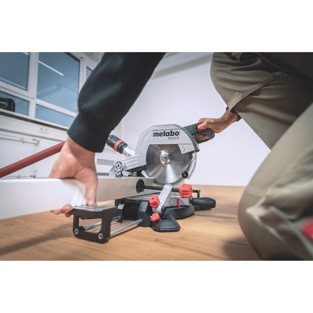 Person sägt mit einer Metabo Kappsäge KS 216 M ein weißes Holzstück.