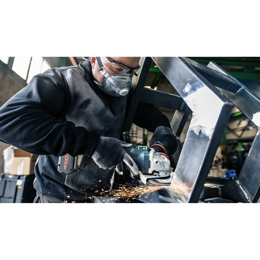 Person schleift Metall mit einem Winkelschleifer.