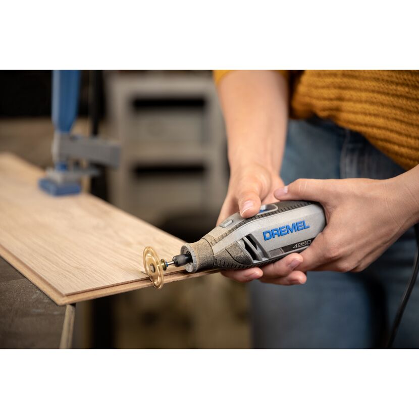Person verwendet Dremel 4250 Multifunktionswerkzeug zum Schneiden von Holz.