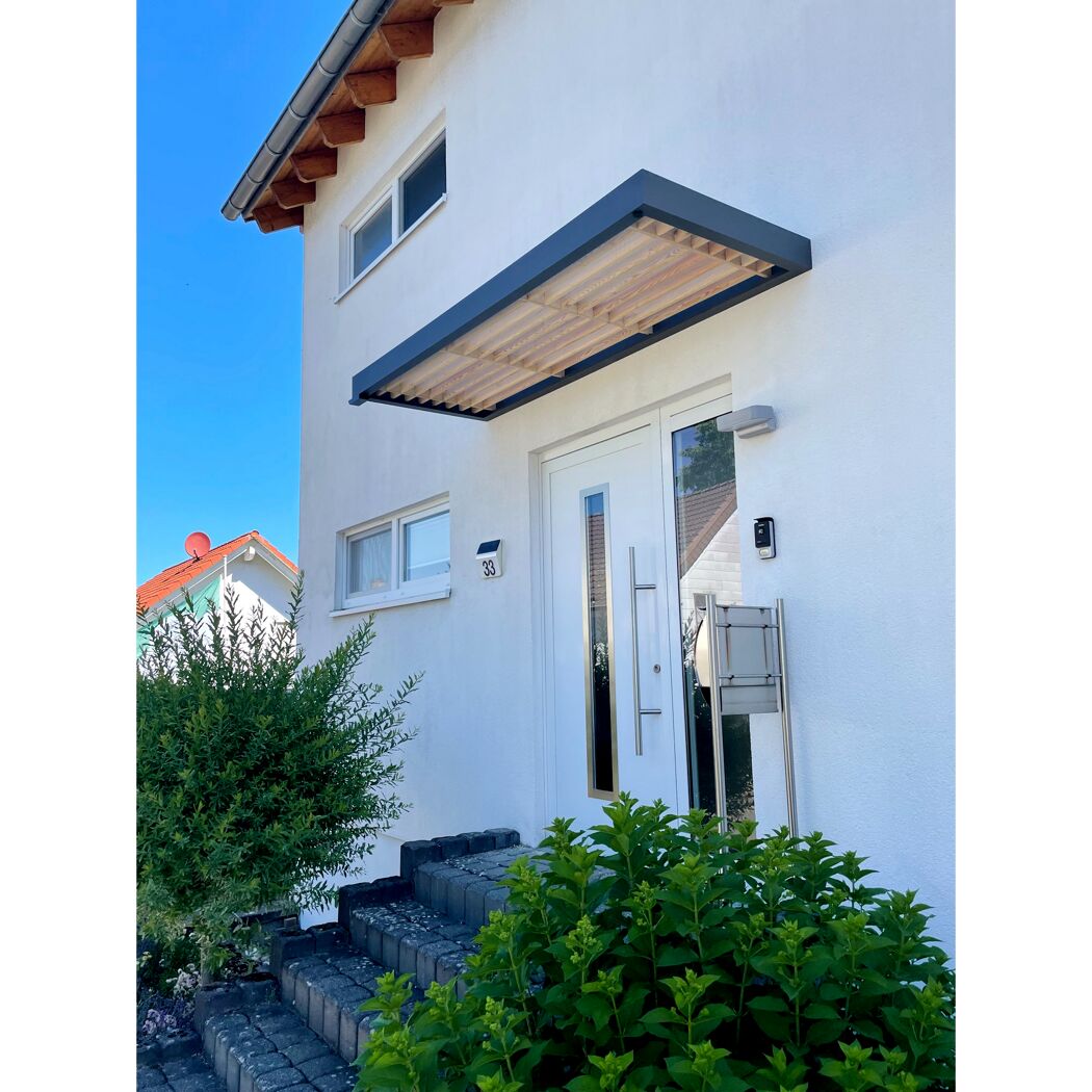 Weißer Hauseingang mit Vordach aus Holz und Metall