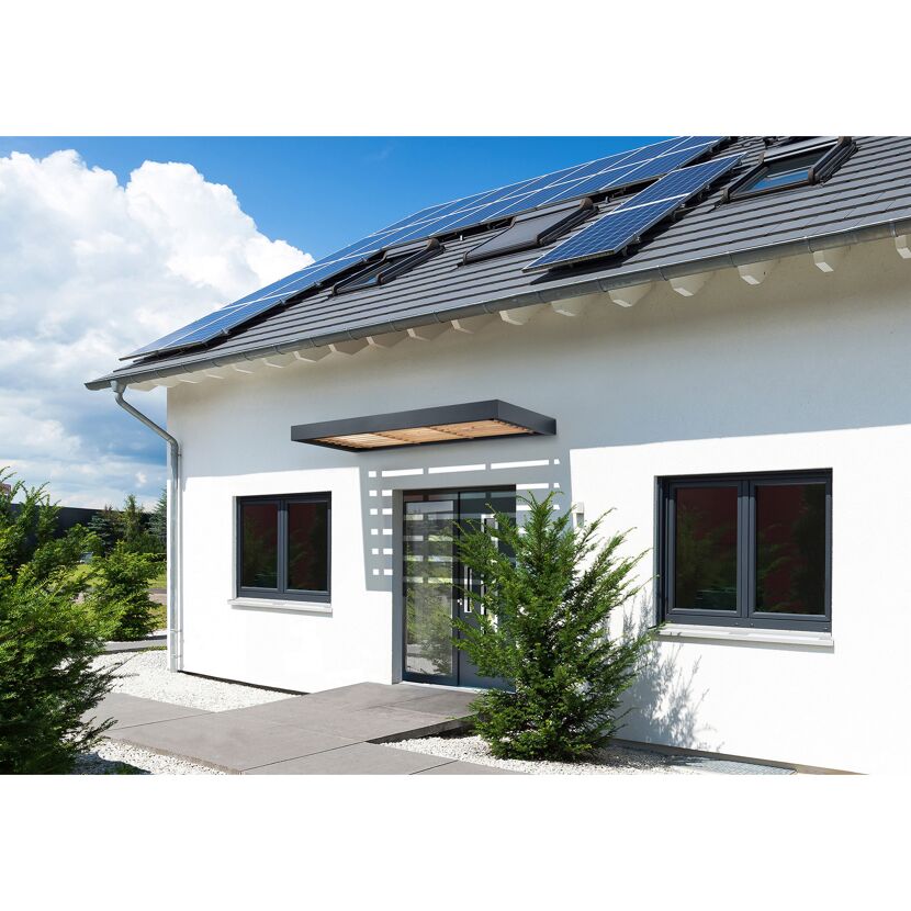 Weißes Haus mit Solaranlage auf dem Dach und Vordach.
