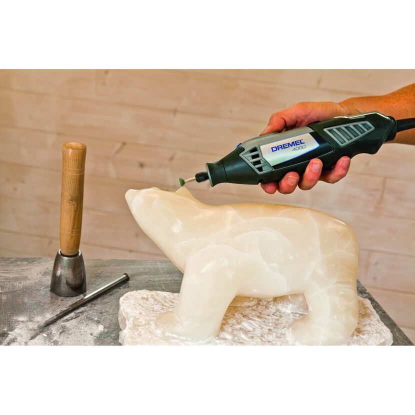Person bearbeitet eine Alabaster-Bärenfigur mit einem Dremel 4000.