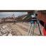 Person verwendet Nivelliergerät auf Baustelle