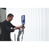 Person bringt mit einer Blindnietmutterzange ein Parkschild an.