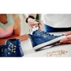 Person verwendet eine Ösenzange an einem blauen Schuh