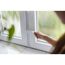 Person verschließt ein Fenster mit einem Schlüssel.